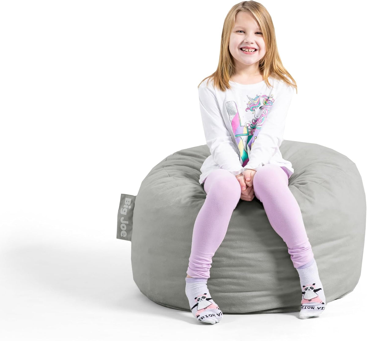 Child sitting on a large gray corded bean bag with a fabric tag at the side