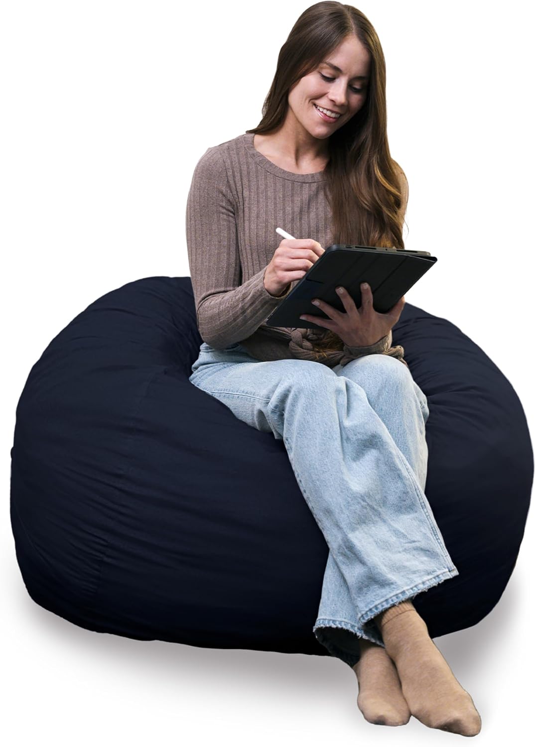 Smiling woman seated on a navy lounger using a tablet, legs folded at the front.