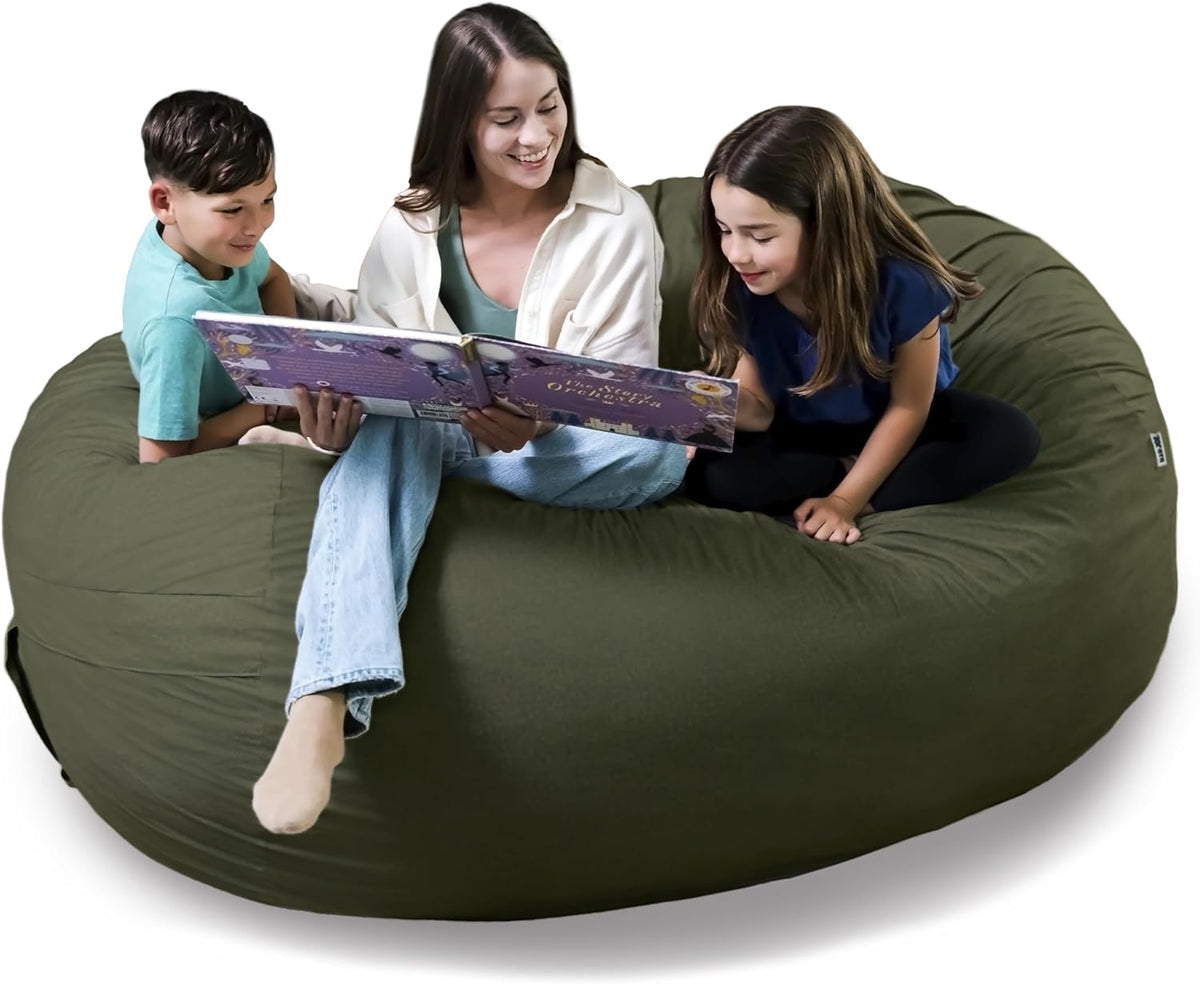 Adult and two children sitting together on a large olive-green bean bag while reading