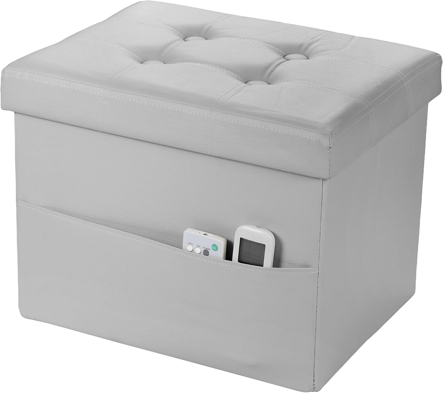 Light gray faux-leather storage ottoman with tufted lid and front pocket containing two small remotes