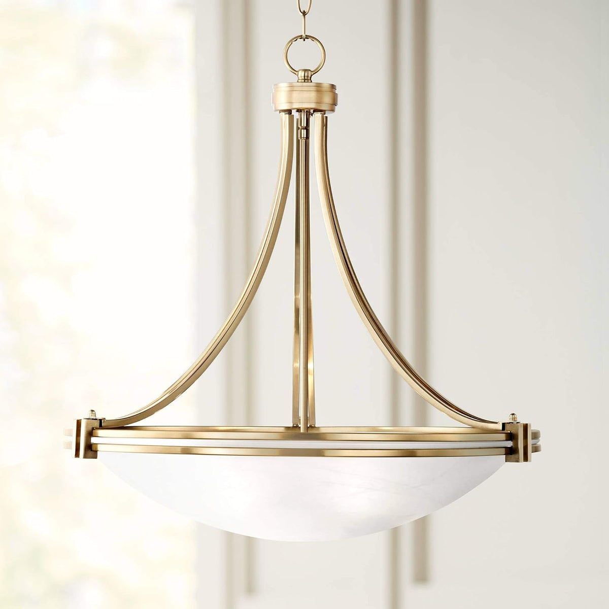 Warm brass pendant top and curved metal arms with partial satin white glass bowl close-up