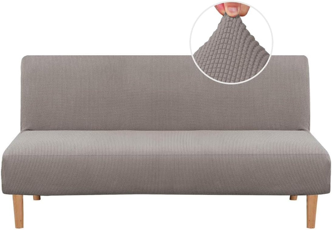 Front view of a slim armless sofa dressed in a light gray small-check textured slipcover