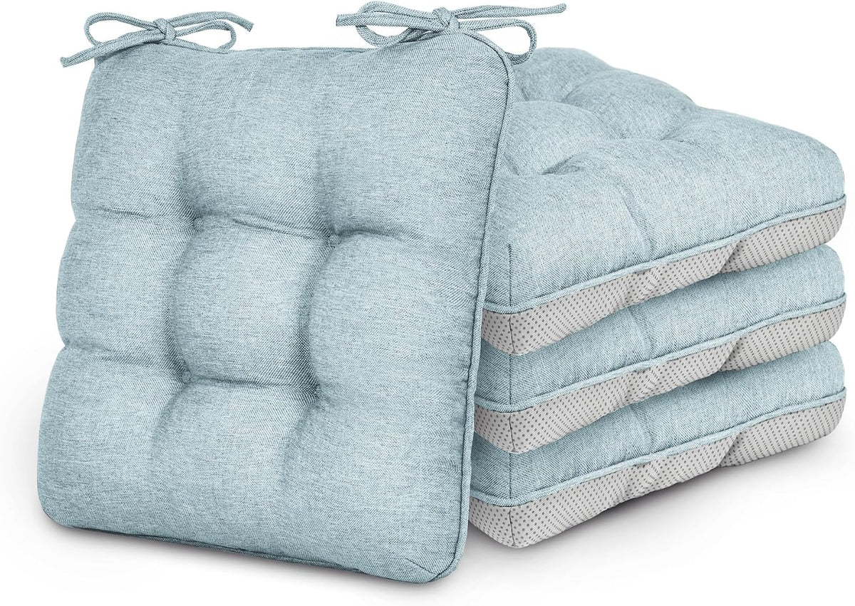 Four pale blue tufted chair cushions stacked, front cushion showing tied corner straps.