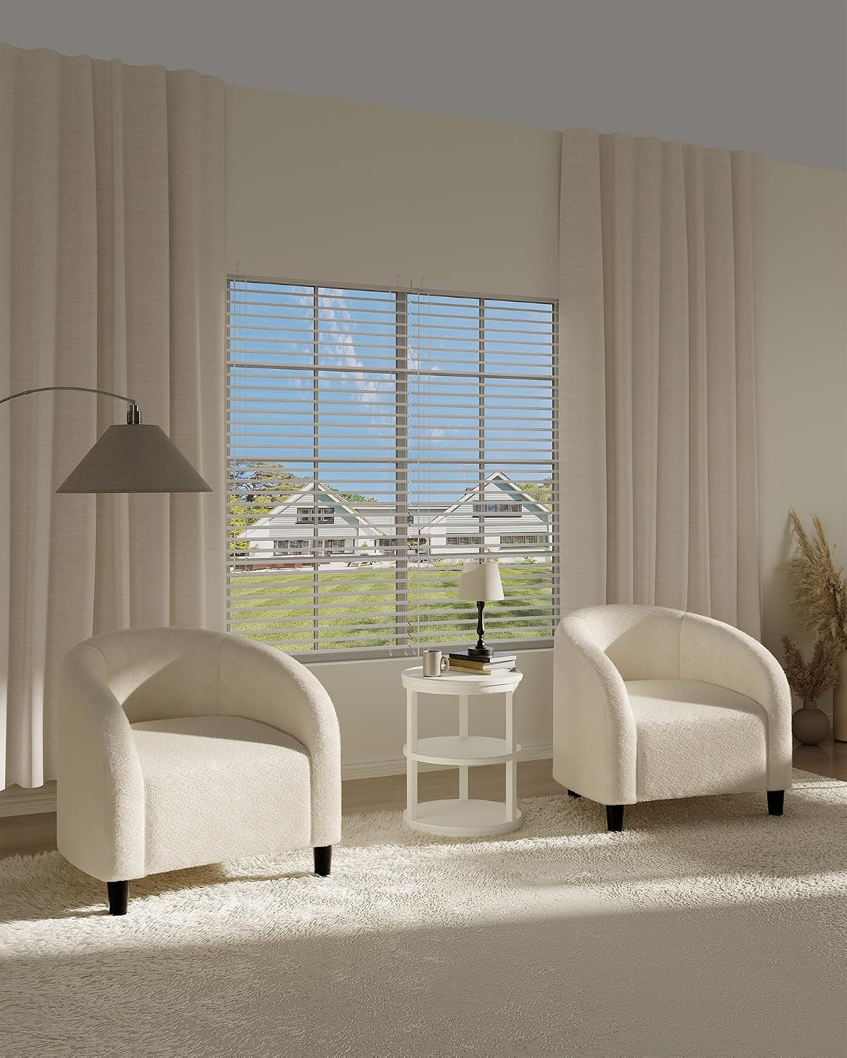 Two beige boucle barrel chairs flanking a small round side table in a sunlit living room.