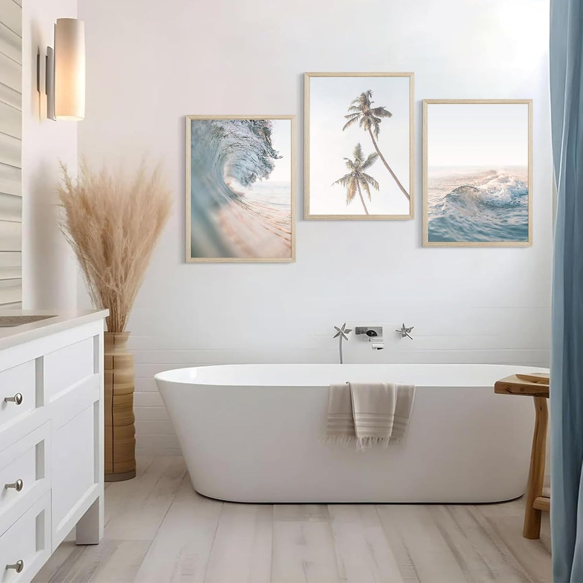Bathroom scene with a freestanding tub beneath three framed coastal ocean and palm tree prints on the wall.