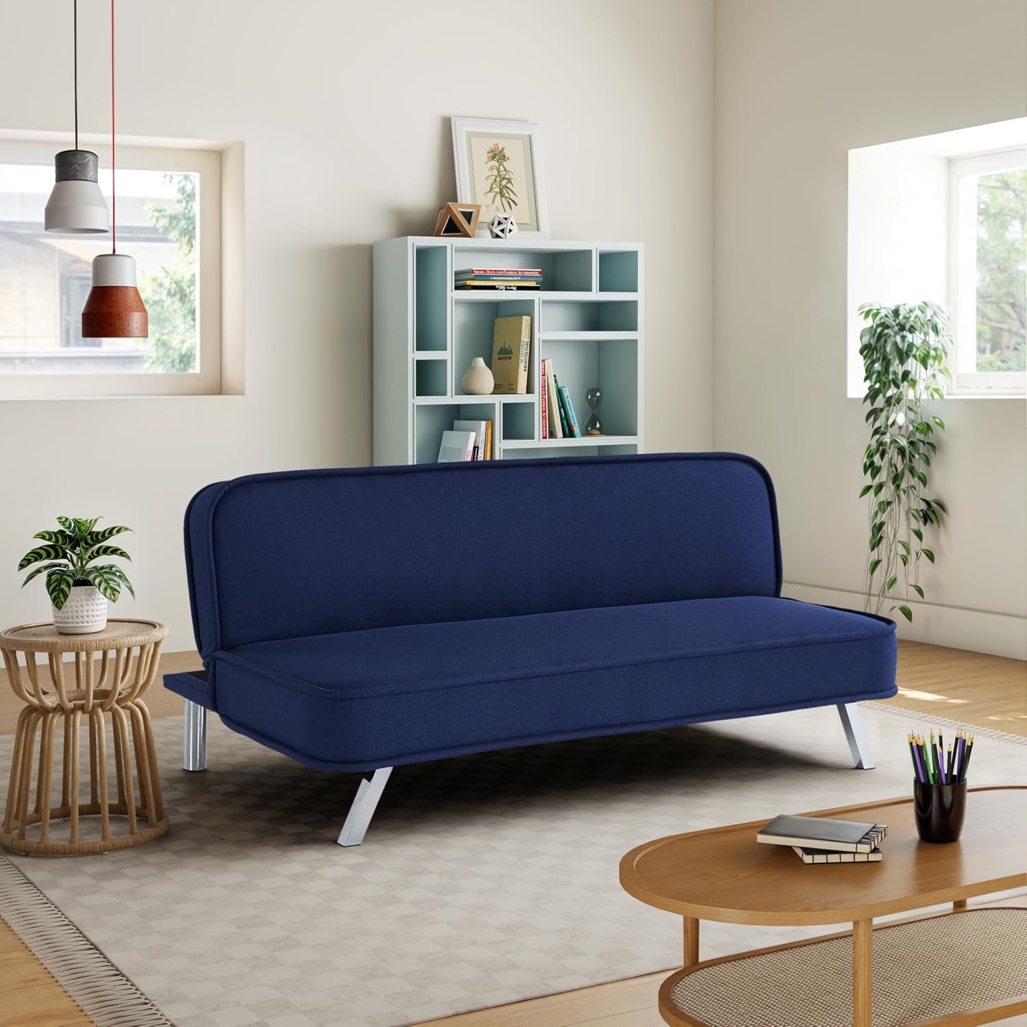 Navy convertible futon sofa shown in a living room angled front view with metal legs