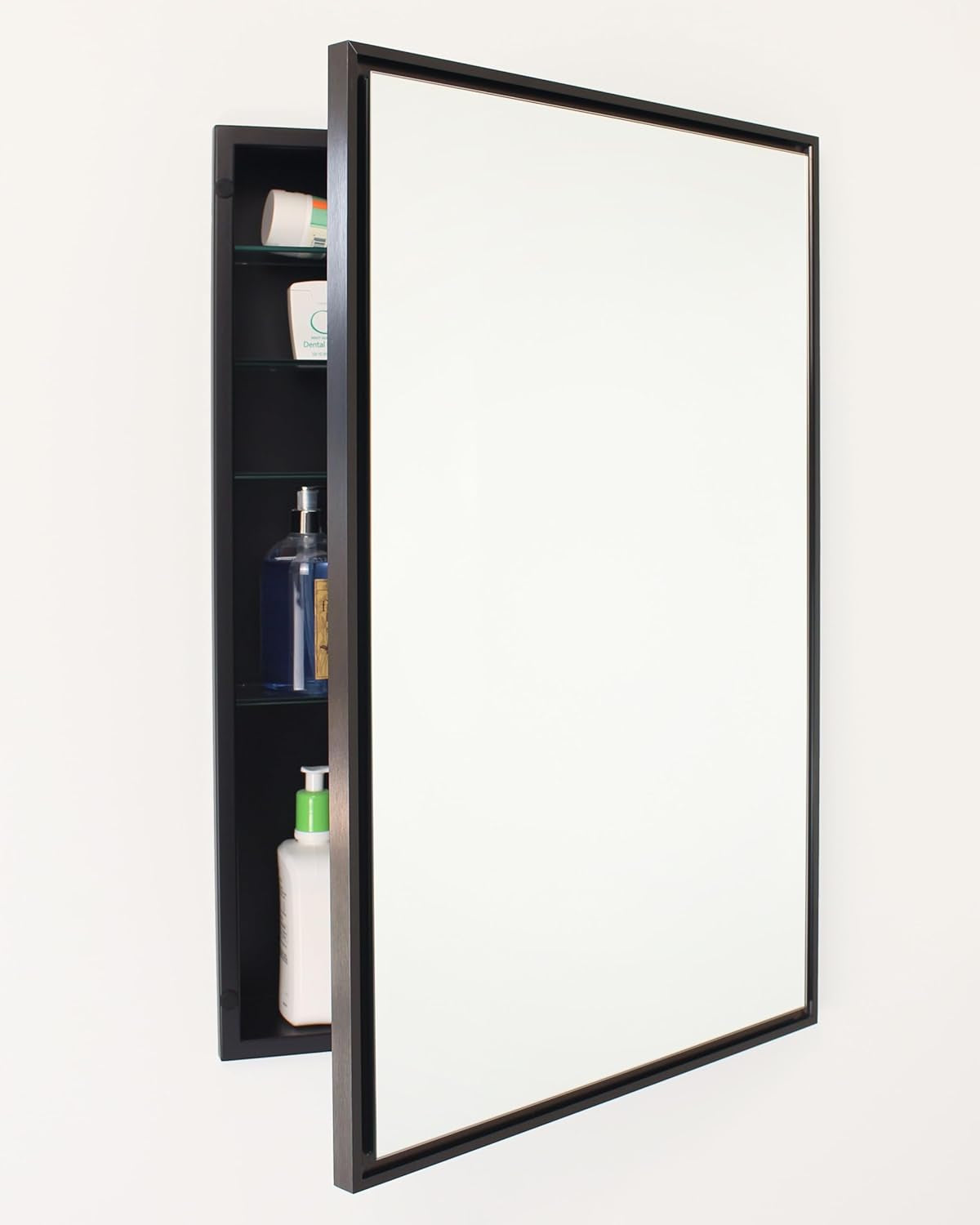 Black-framed recessed medicine cabinet, door open to show dark interior and three glass shelves with bottles.