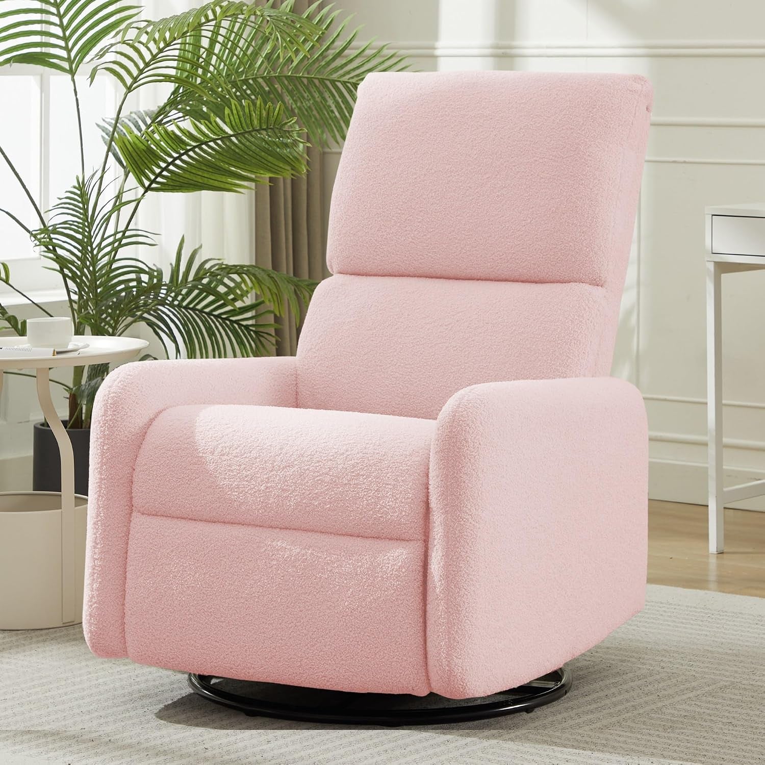 Blush pink sherpa glider chair angled front with padded high back and black swivel base in a living room setting.