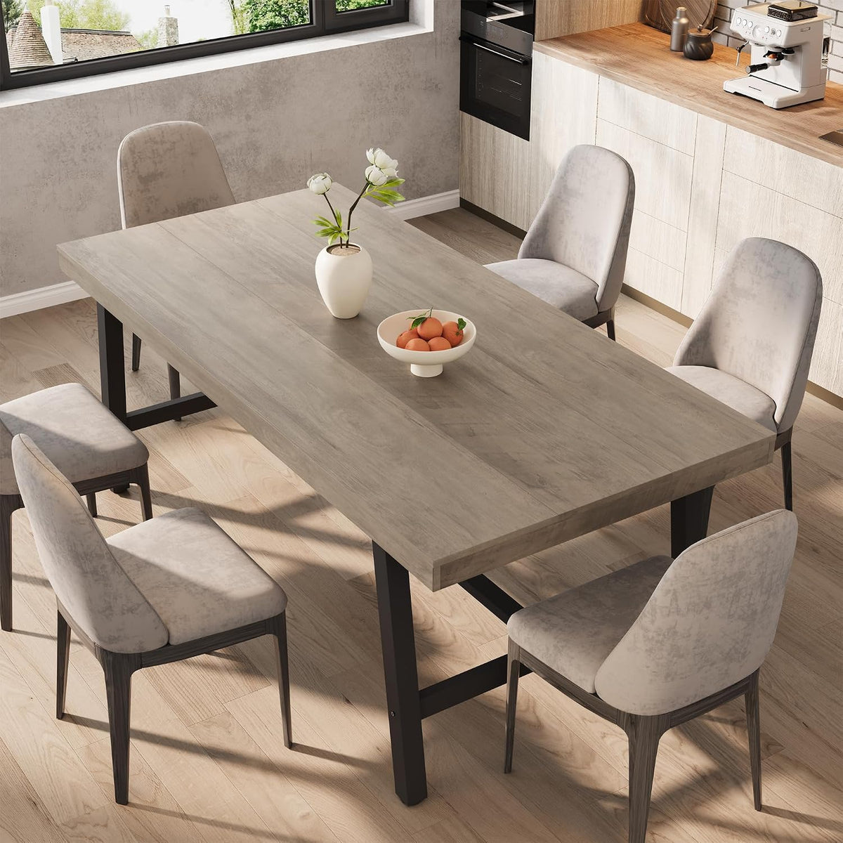 Top-down lifestyle shot of the table in a light finish with bowl of fruit and vase, paired with gray dining chairs.
