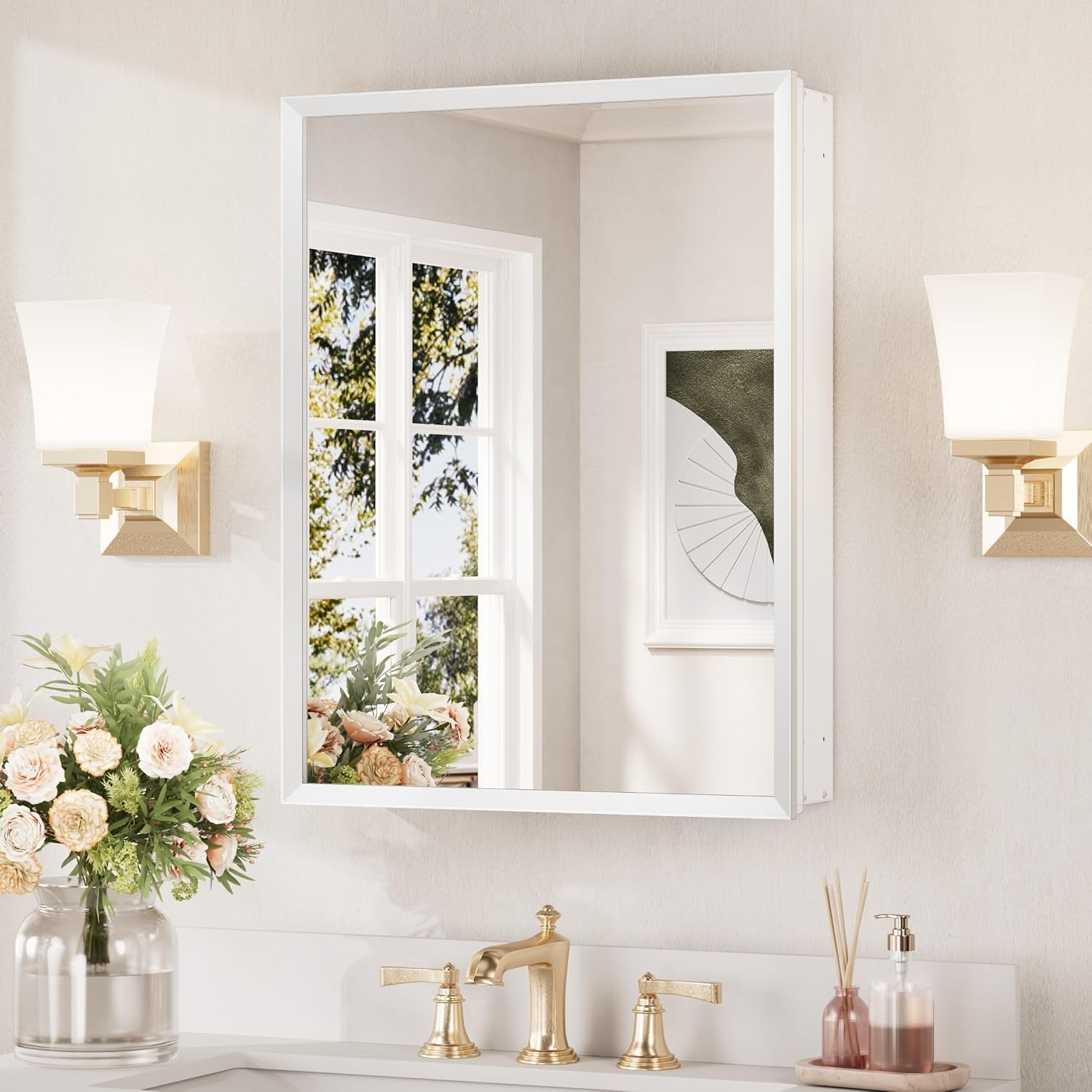 Single-door mirrored medicine cabinet in white mounted above a sink with wall sconces.