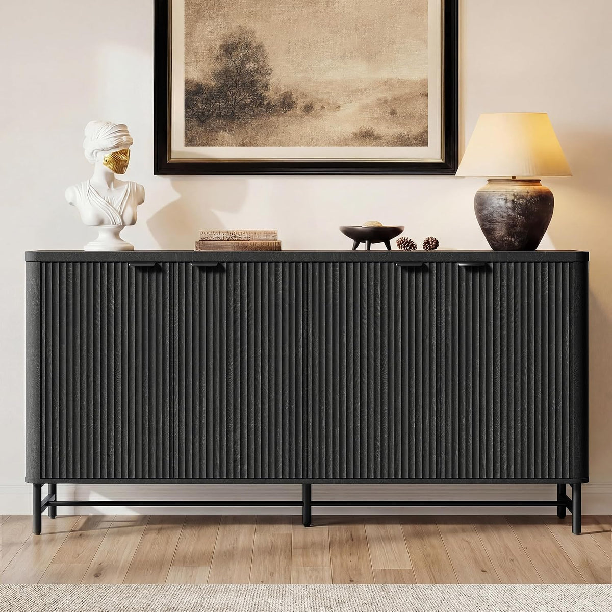 Close frontal view of a black ribbed-front buffet on slim metal legs with decor above