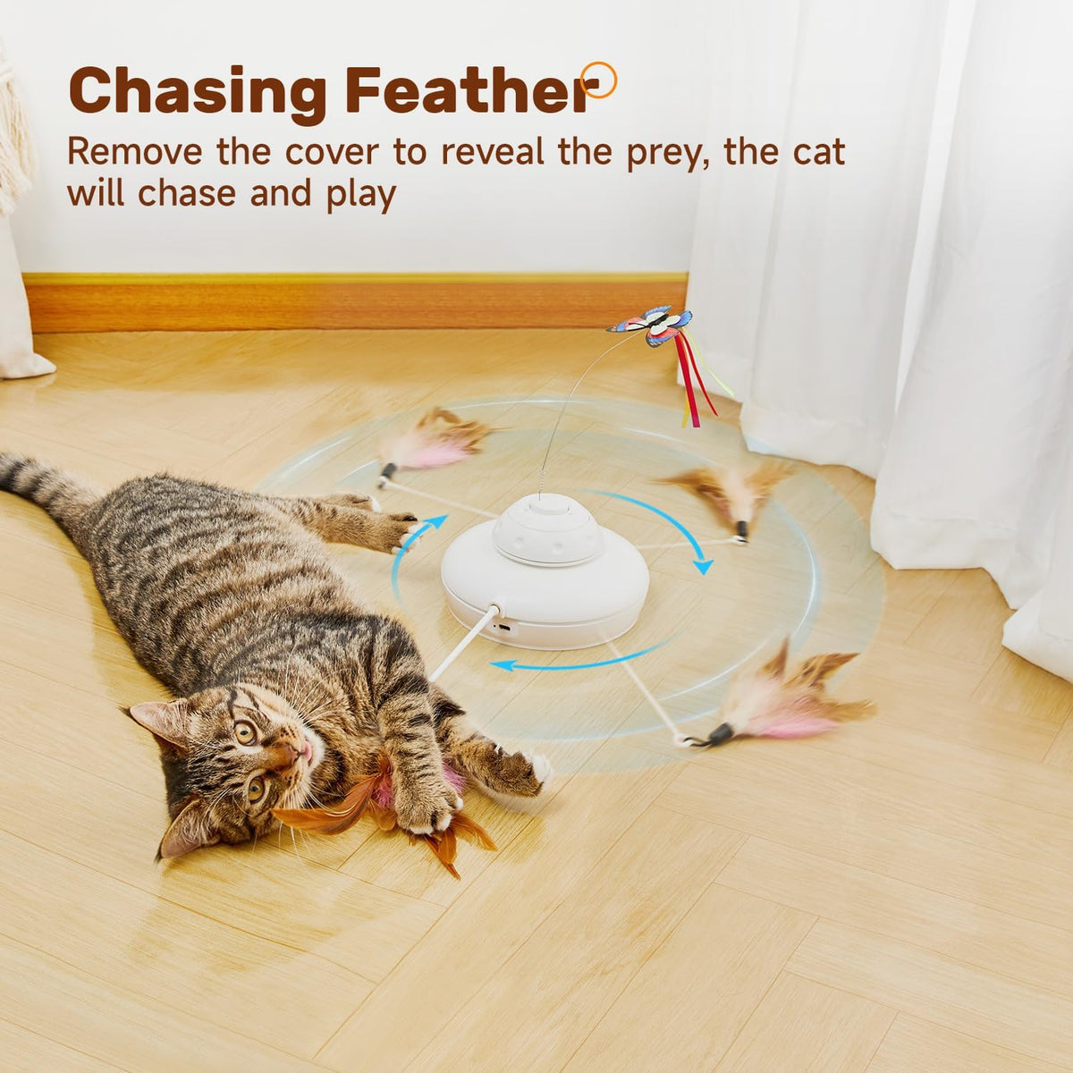 Tabby cat on a wood floor playing with a white spinning base toy and feather attachments.