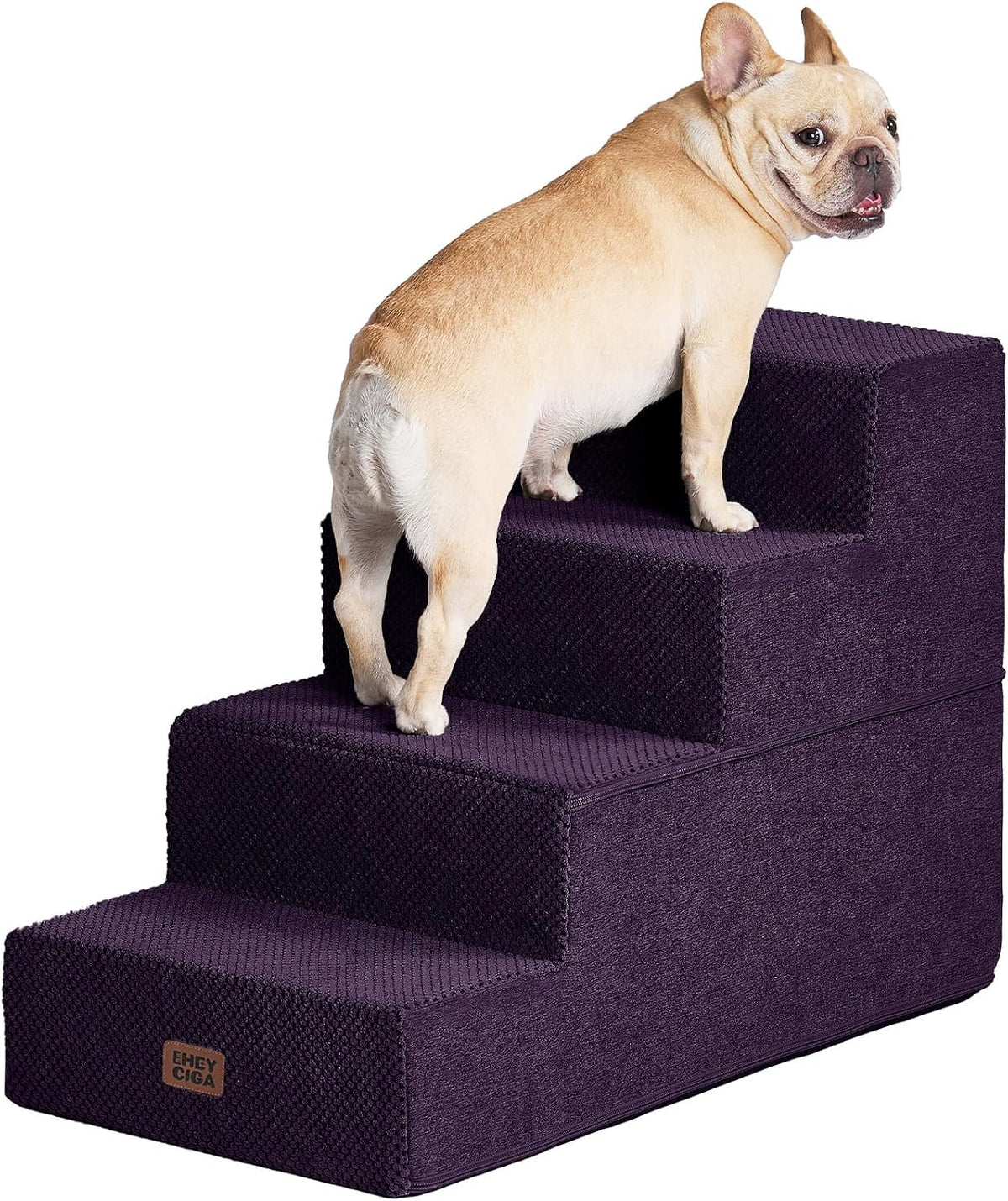 Rear three-quarter view of a tan French bulldog climbing deep purple foam stairs, looking back over its shoulder.