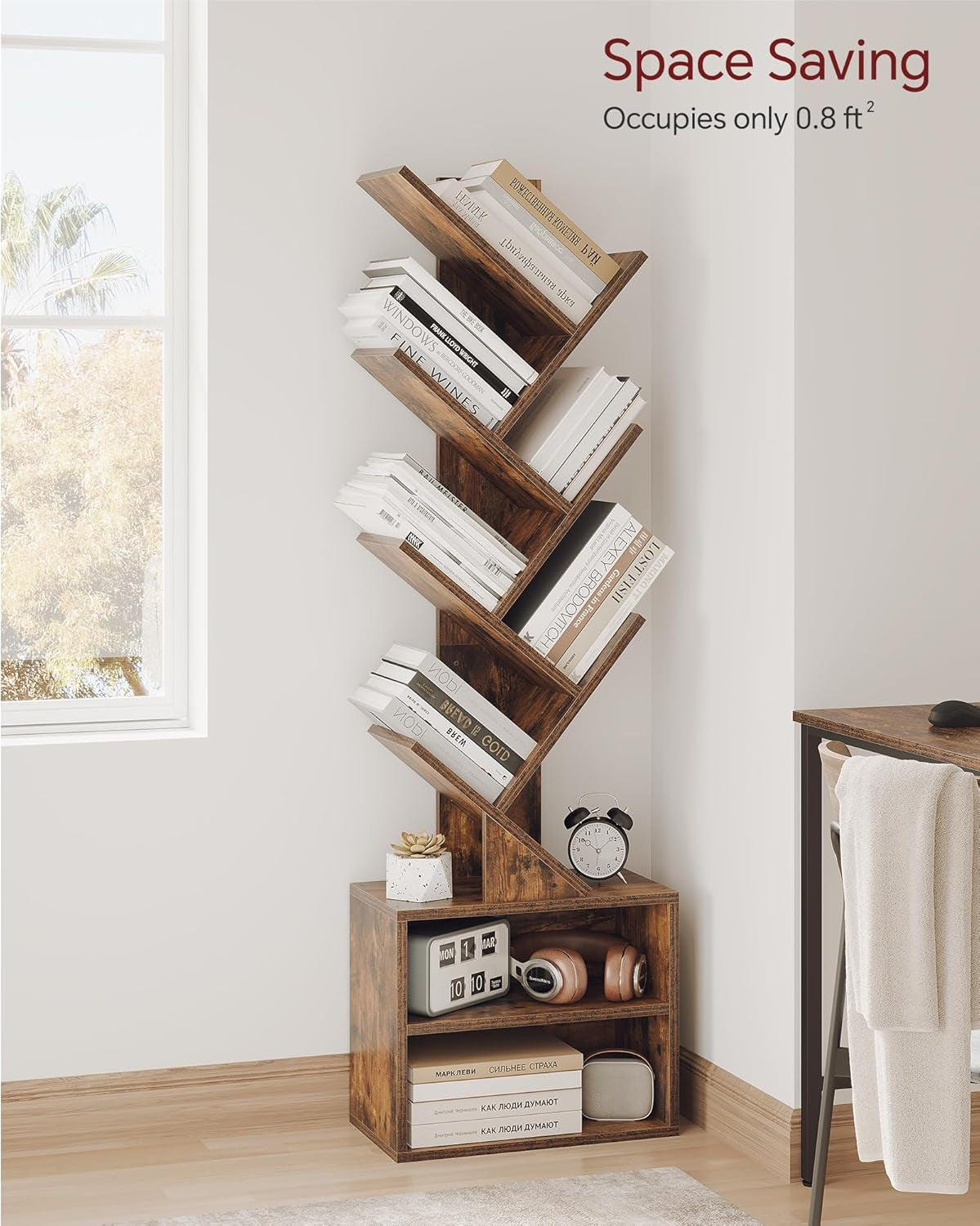 Bookshelf placed in a bright corner by a window, holding angled books, a clock and small decor on the lower cabinet shelves.