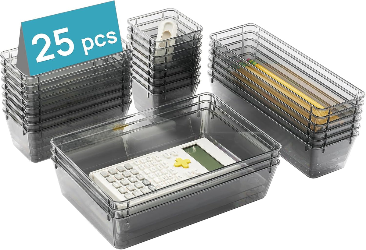 Angled view of stacked smoky translucent plastic trays with a calculator inside a large tray and pencils in a long tray.