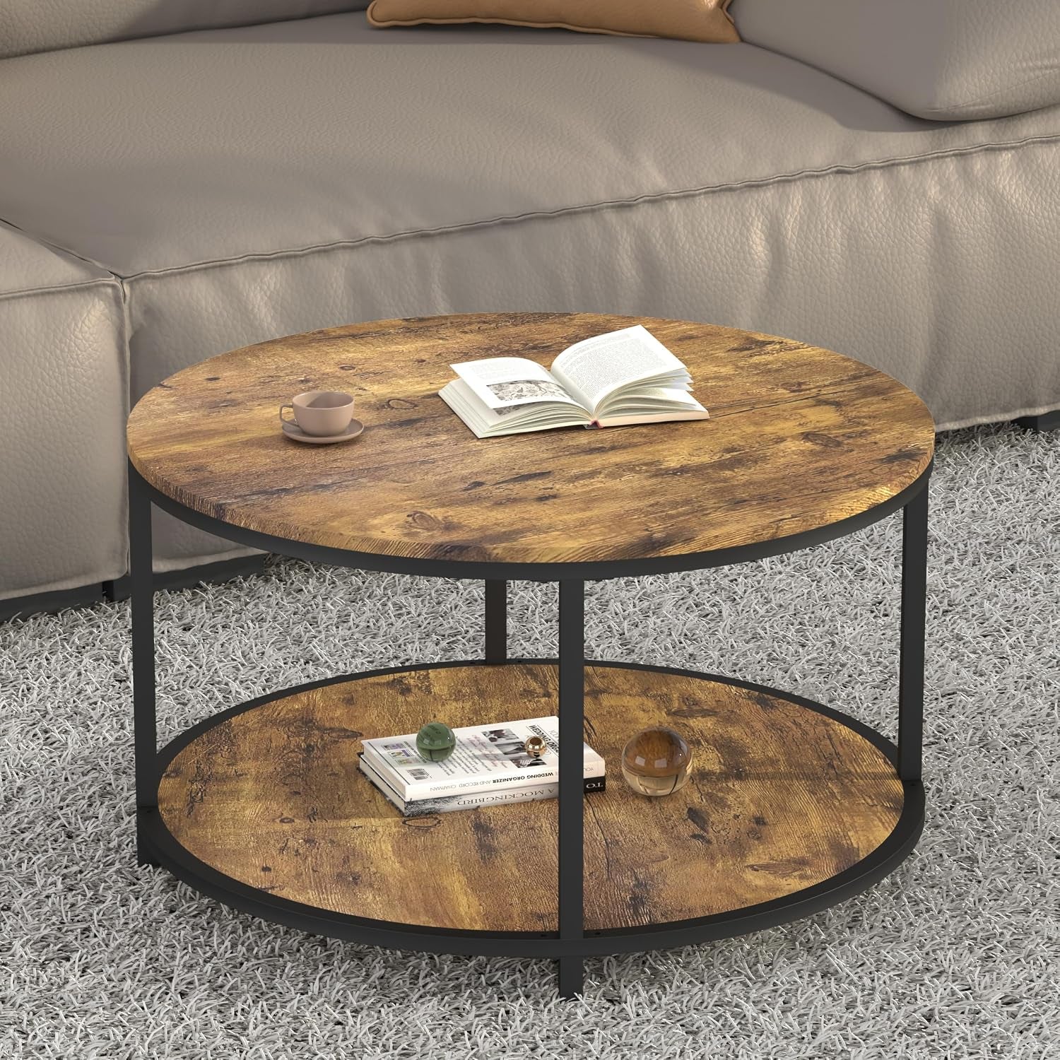Round coffee table viewed slightly from the side showing wood grain top, lower shelf and simple vertical metal supports.