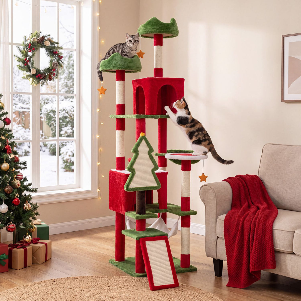 Red and green cat tree with cats climbing and playing beside a decorated window
