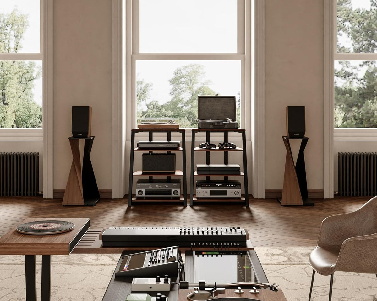 Two walnut-finish media stands side-by-side in a bright living room setting with speakers