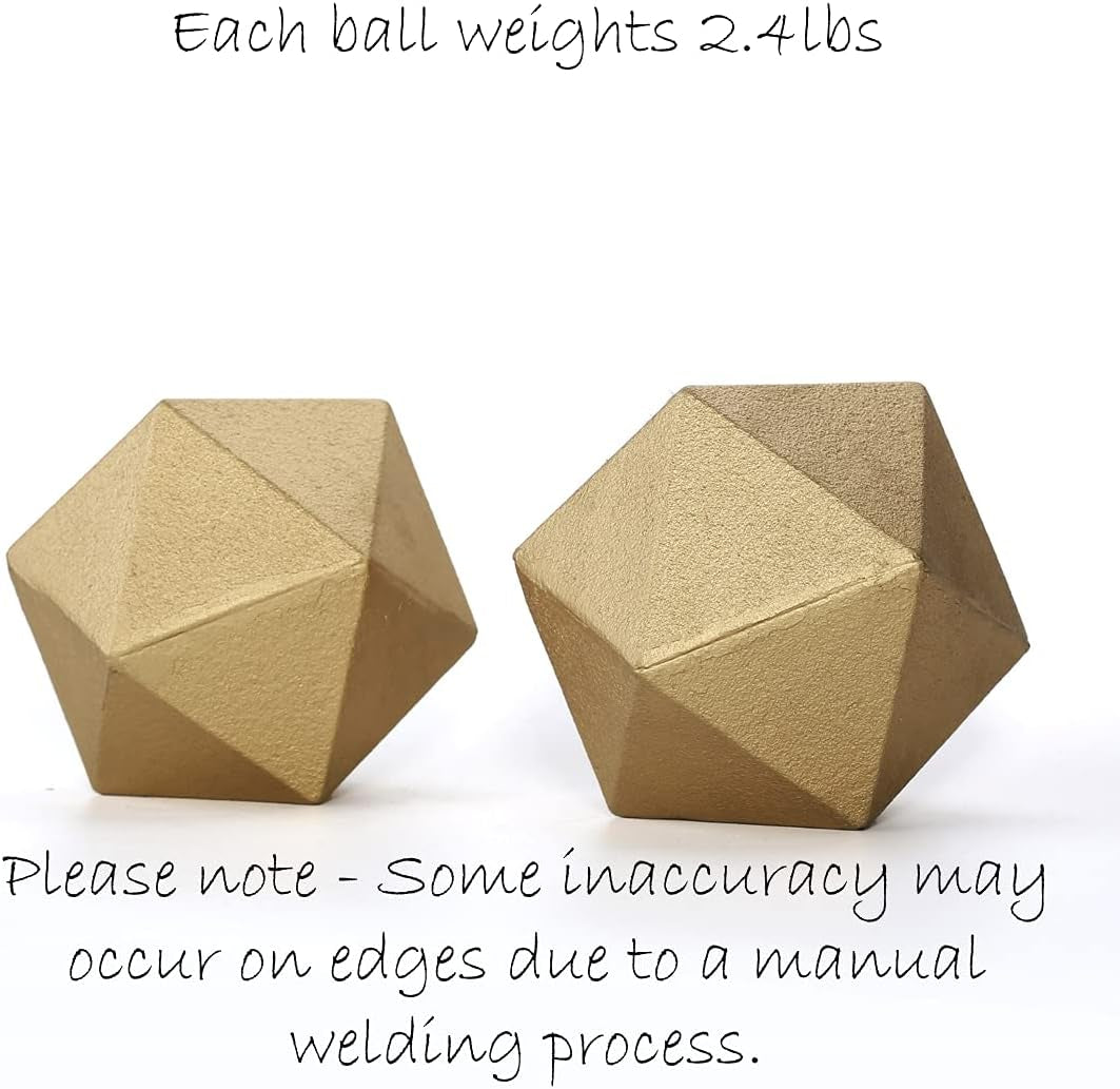 Two gold cast-iron geometric balls on white with visible handwritten note about each ball's 2.4 lbs weight and edge variation
