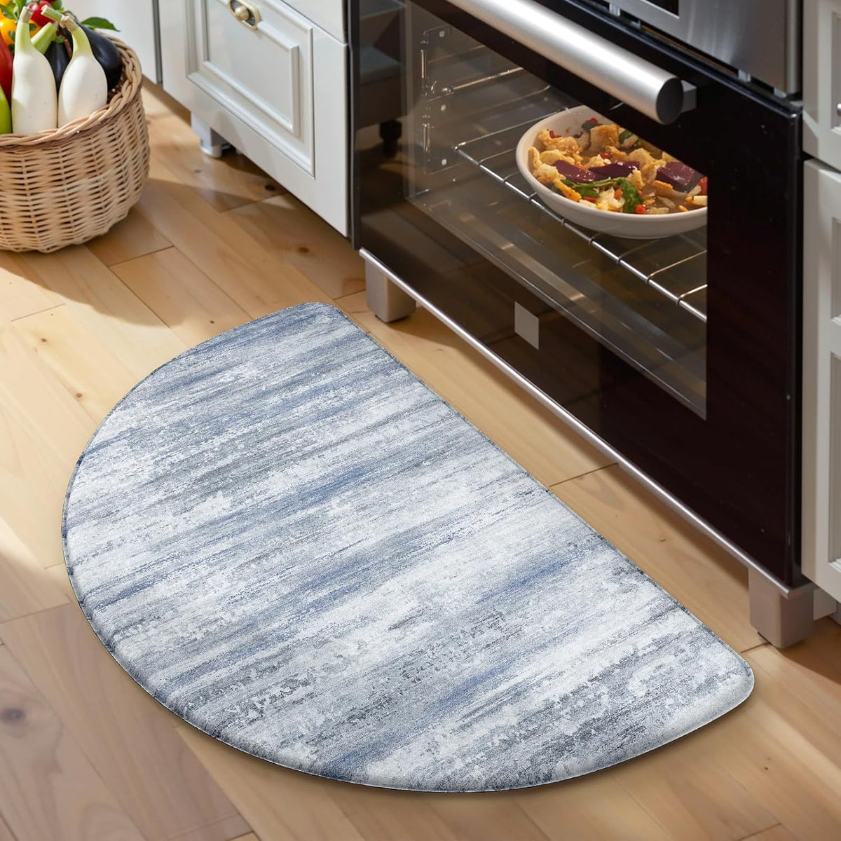 Semicircular blue-gray abstract kitchen mat on wood floor in front of a stainless oven