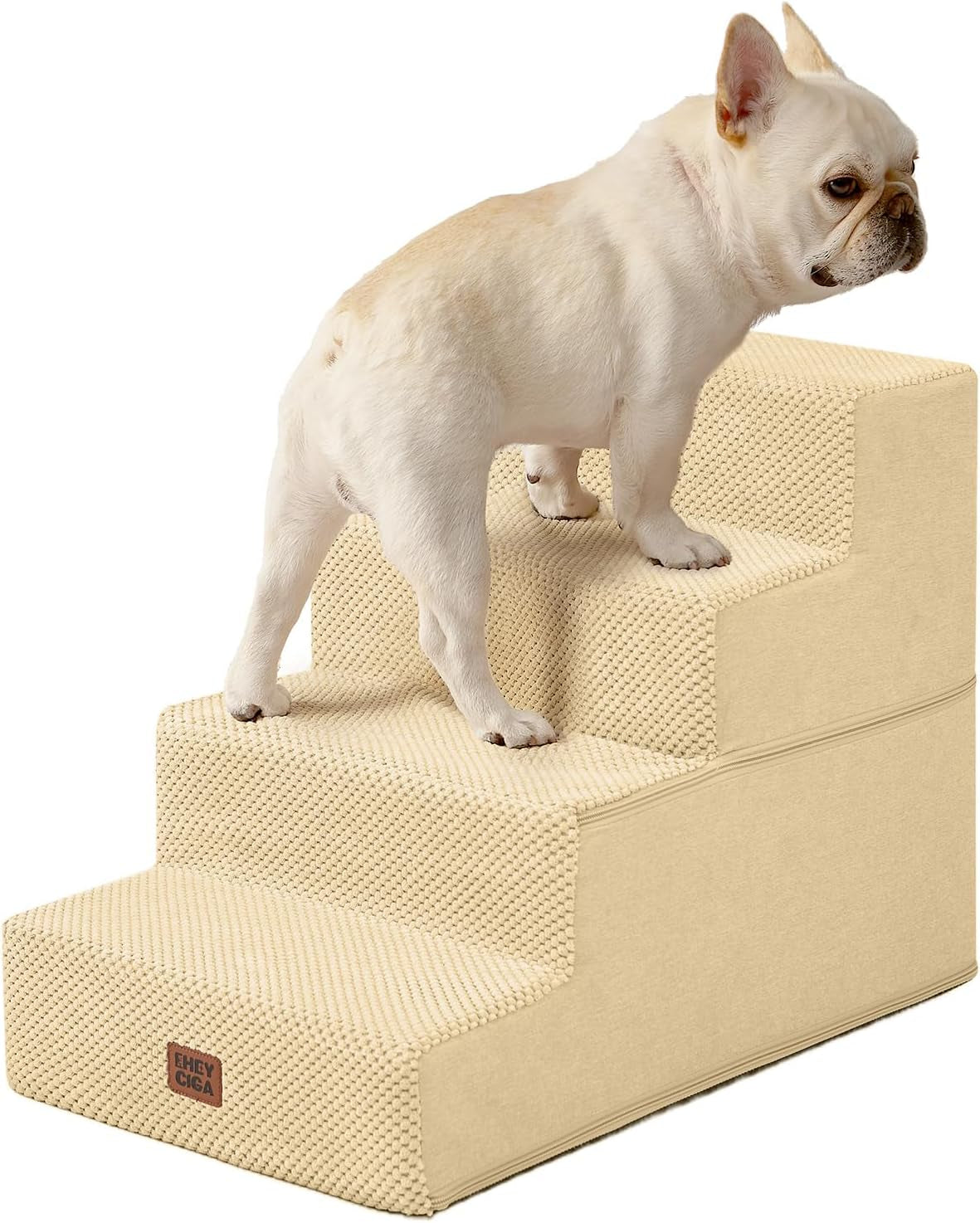 Beige four-step pet stairs photographed from the side with a small white French bulldog standing on them