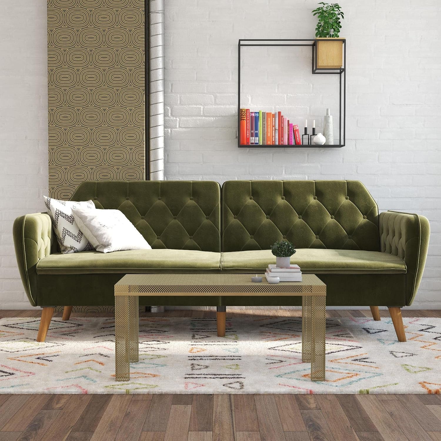 Green tufted velvet futon sofa in a styled living room with coffee table and rug