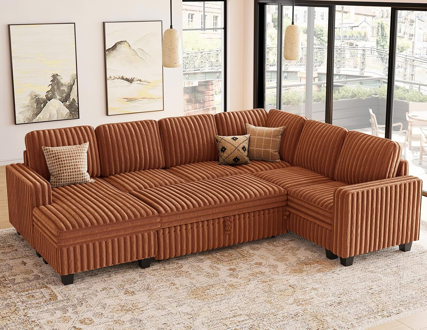 Rust-colored sectional in a bright living room with pillows and large windows