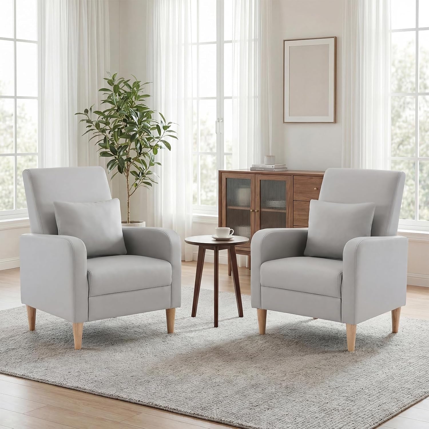Pair of light beige fabric armchairs with wooden legs facing each other around a small round table.