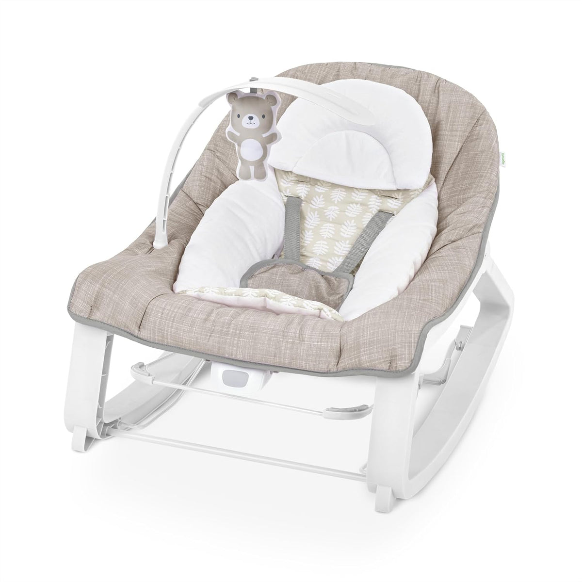 Close overhead view of a neutral-toned baby bouncer seat showing padded insert, harness straps and hanging bear toy.