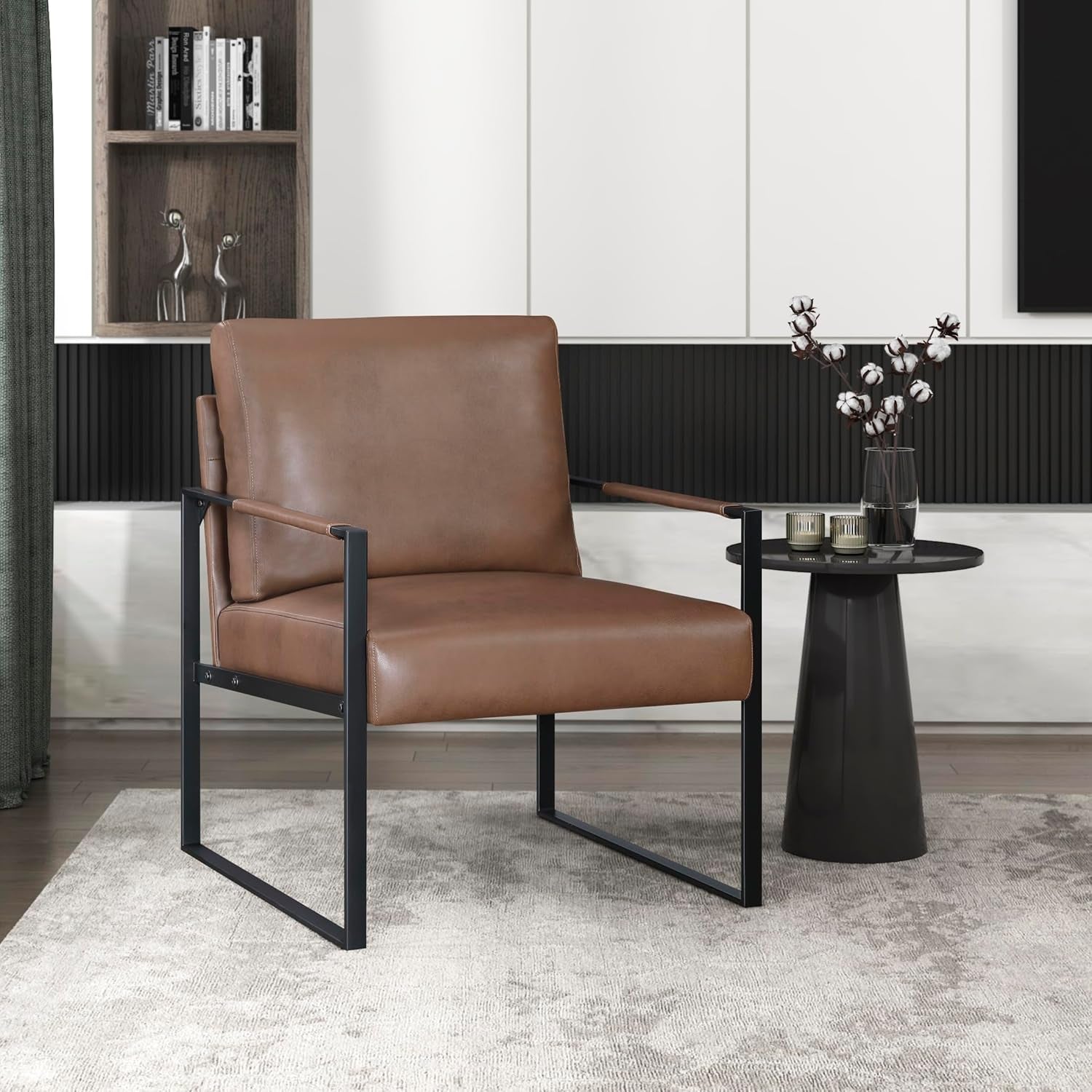 Brown faux leather accent chair angled front-left with black metal frame beside round black side table