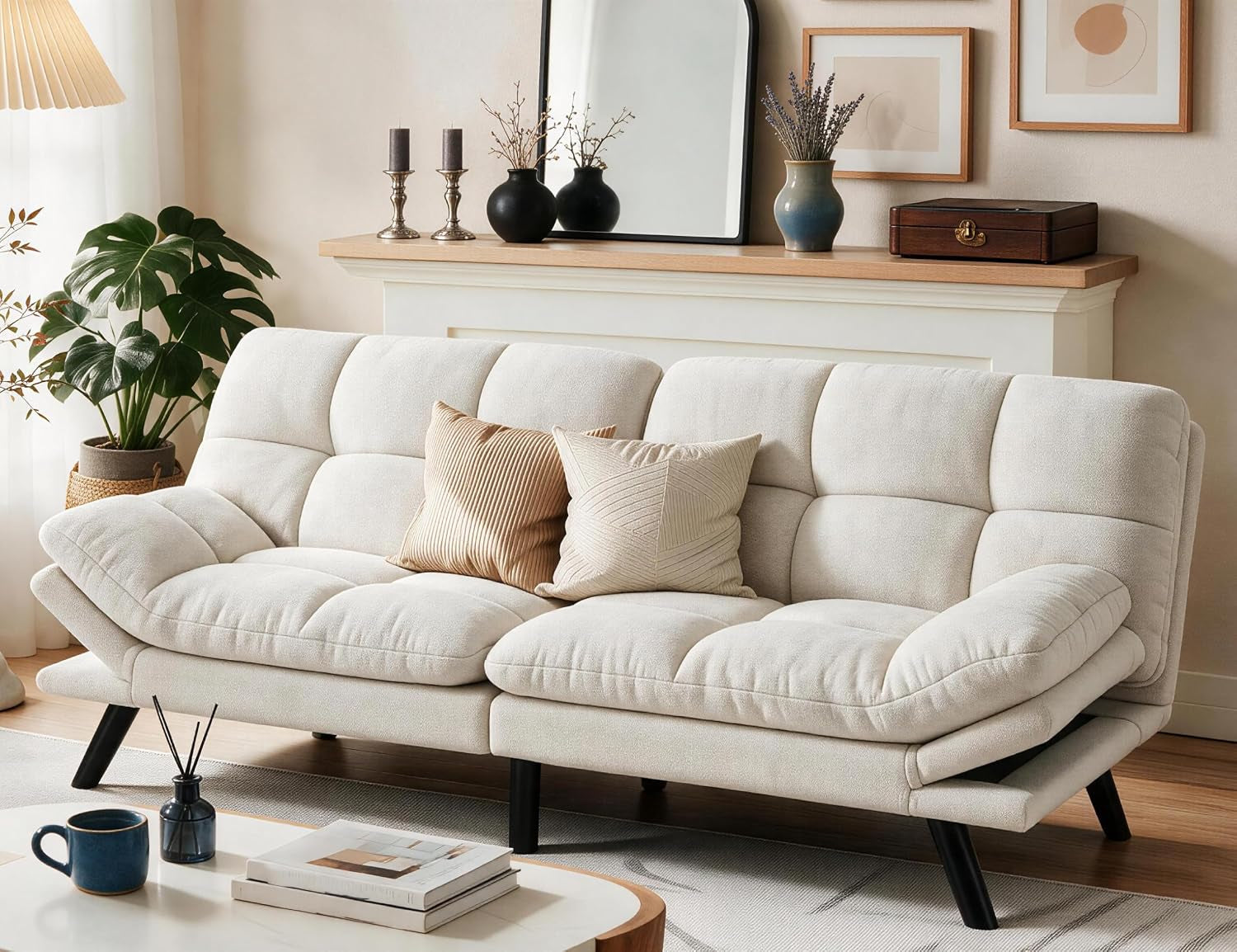 Beige futon sofa straight-on view with two throw pillows in a styled living room