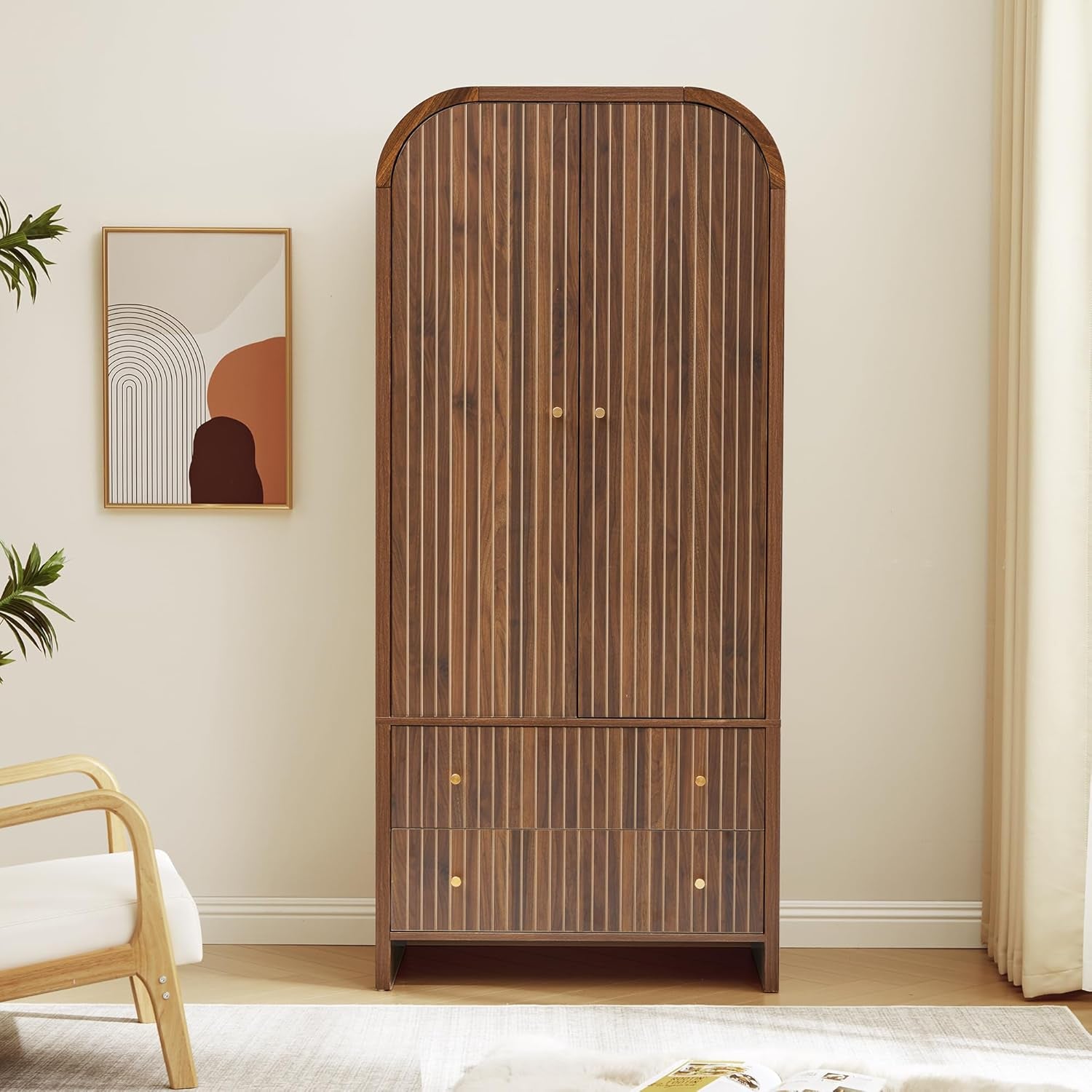 Straight-on front view of the walnut-finish armoire with fluted doors and two lower drawers in a neutral room setting