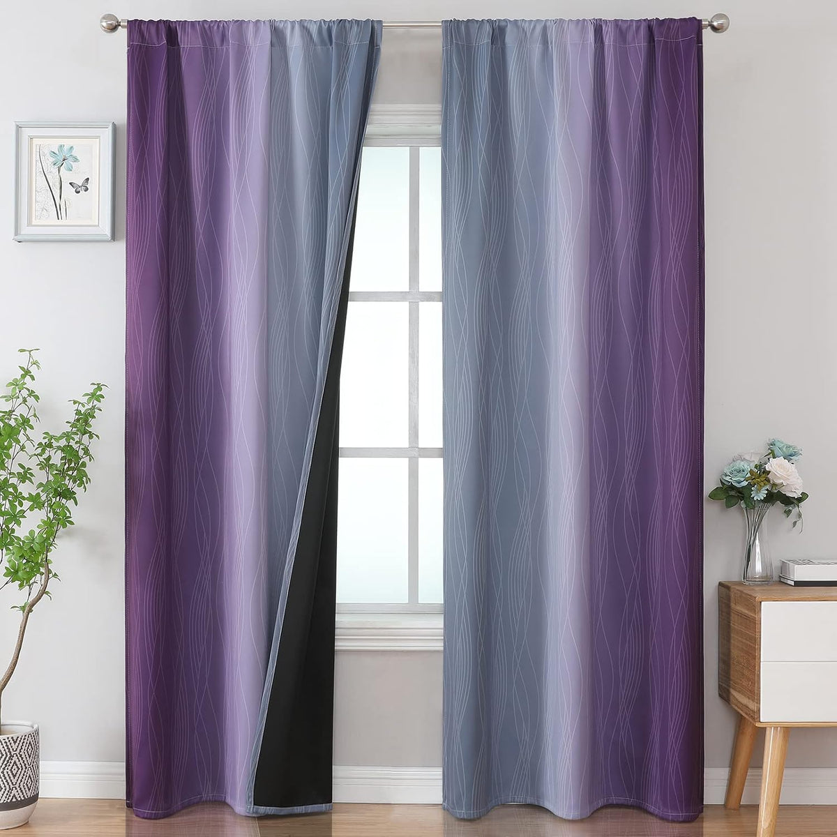 Pair of purple-to-gray ombre curtains hung on a rod framing a window in a styled room.