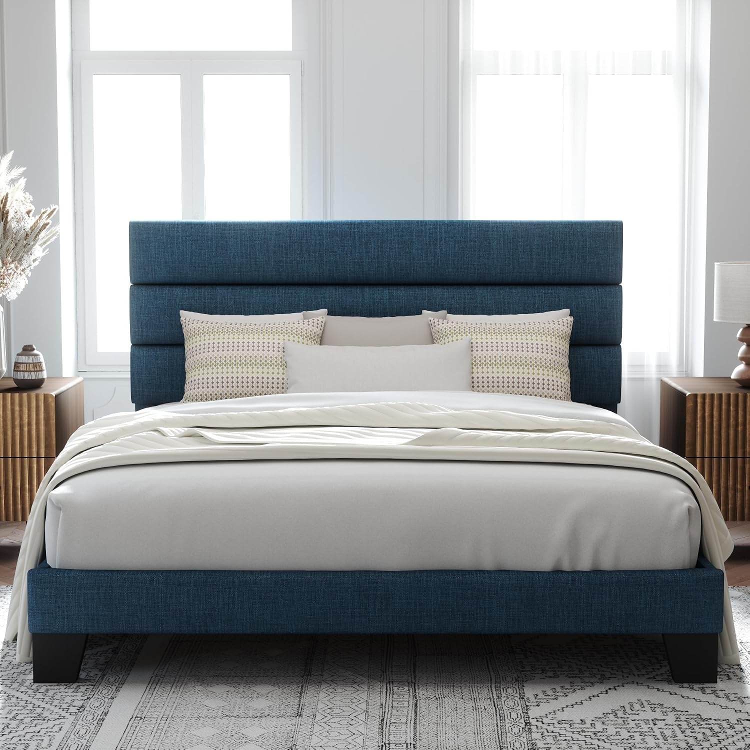Front view of a dark blue fabric bed with a three-panel headboard and matching footboard.