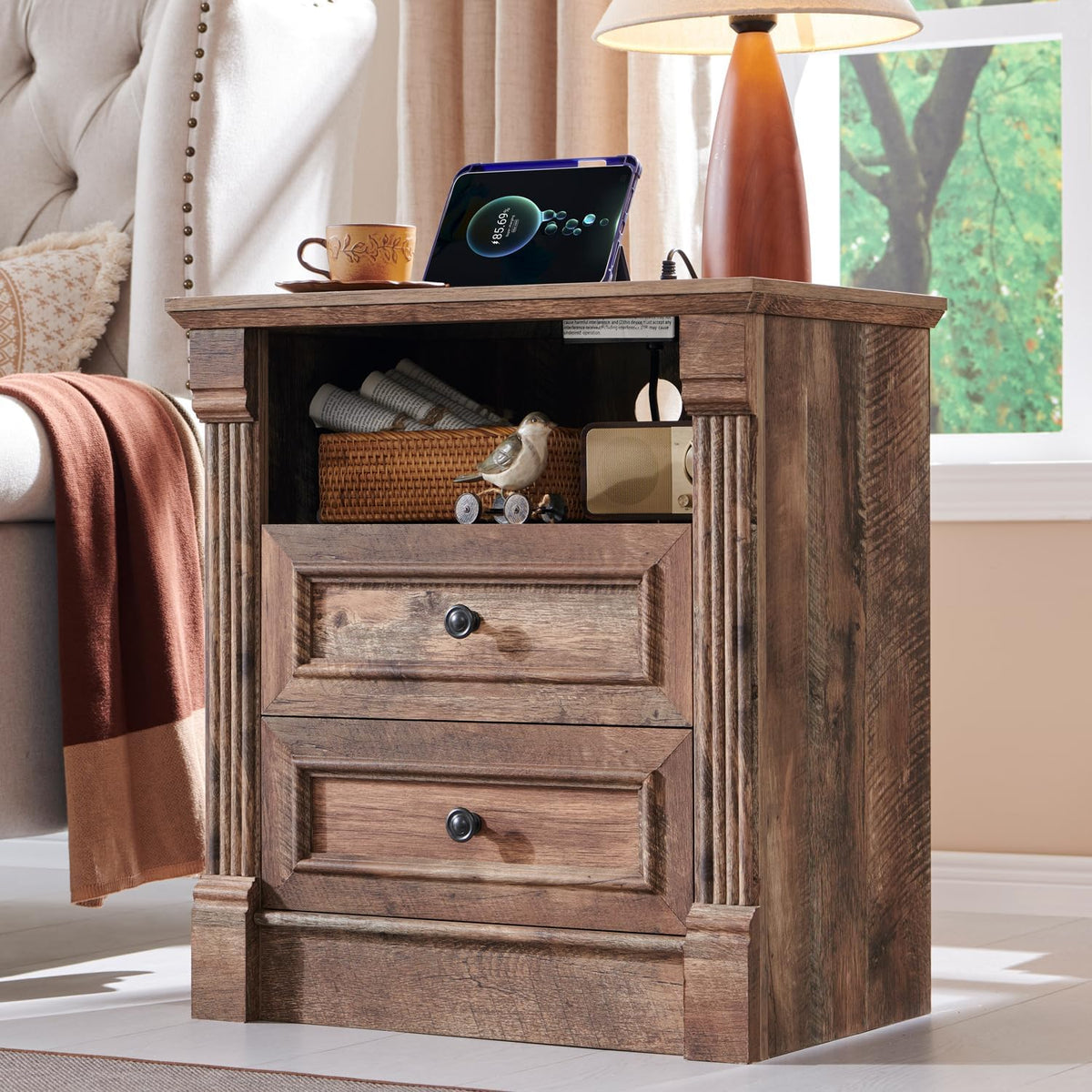Close-up of a two-drawer wood nightstand with open shelf and carved column accents in warm brown finish.