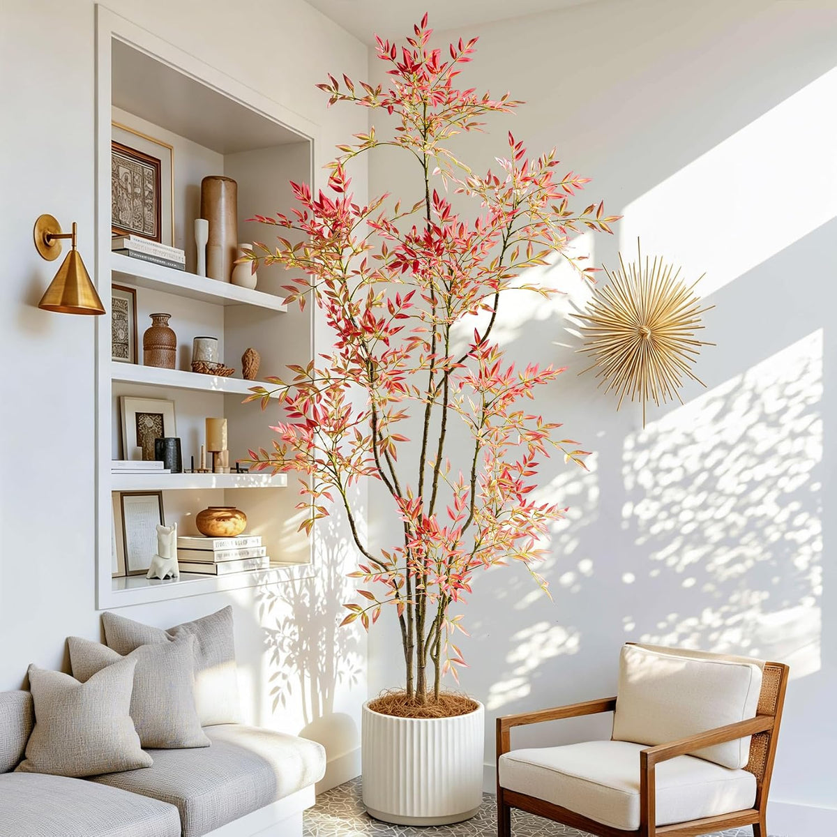 Faux Nandina with variegated red leaves in a fluted white planter beside built-in shelves in a living room