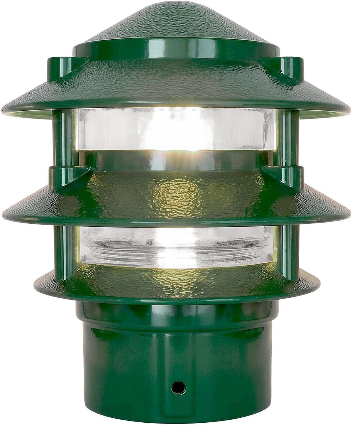 Close-up of green pathway light showing textured metal tiers and clear glass lens lit from inside