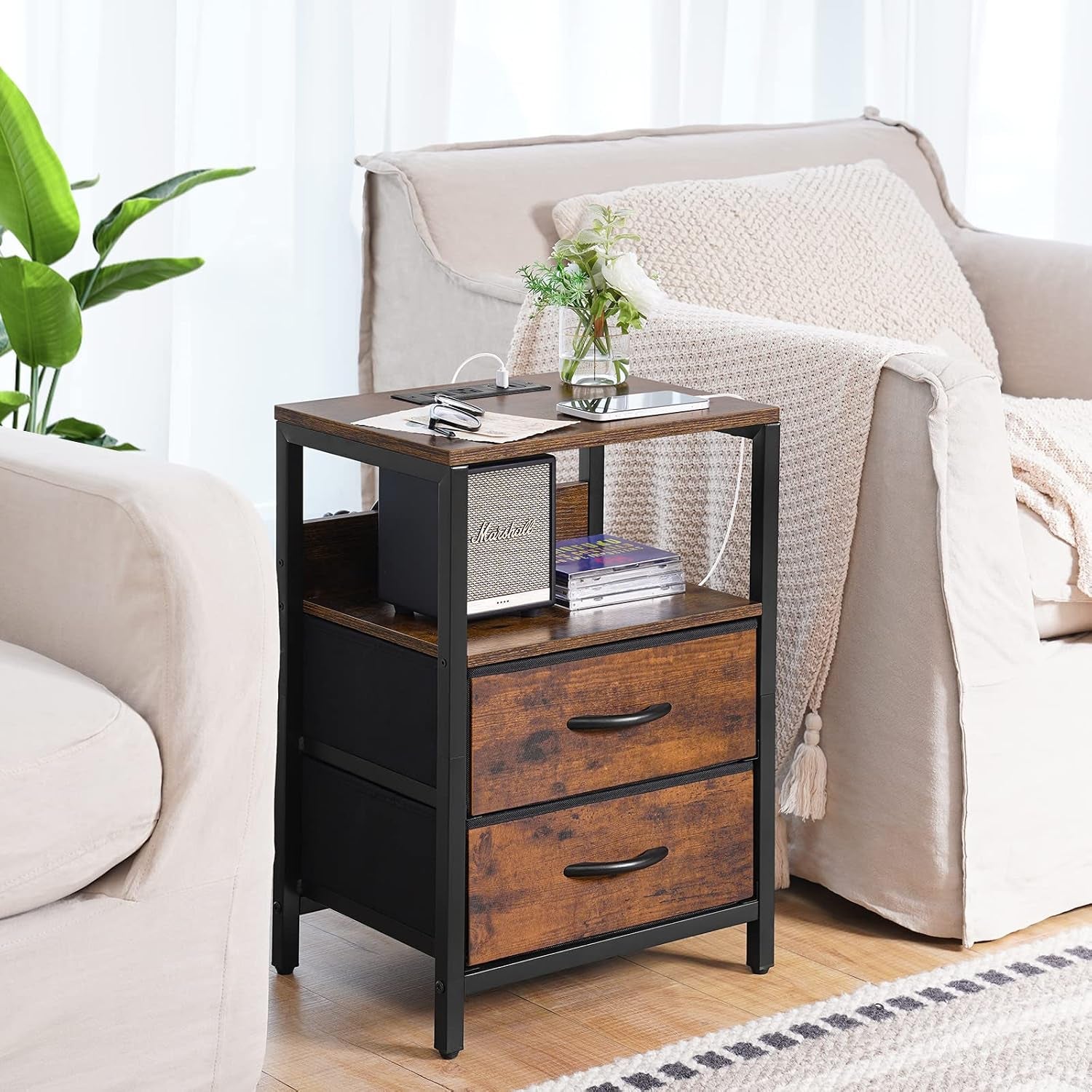 Rustic brown nightstand placed beside a beige sofa showing open shelf and two fabric drawers in a living room setting