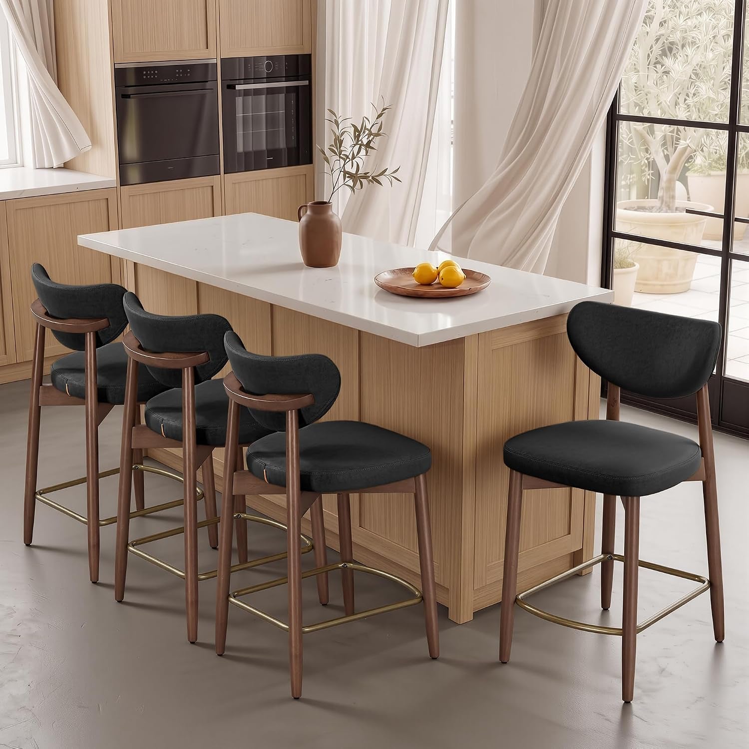 Four dark gray upholstered bar stools with wooden frames lined up along a light wood kitchen island.