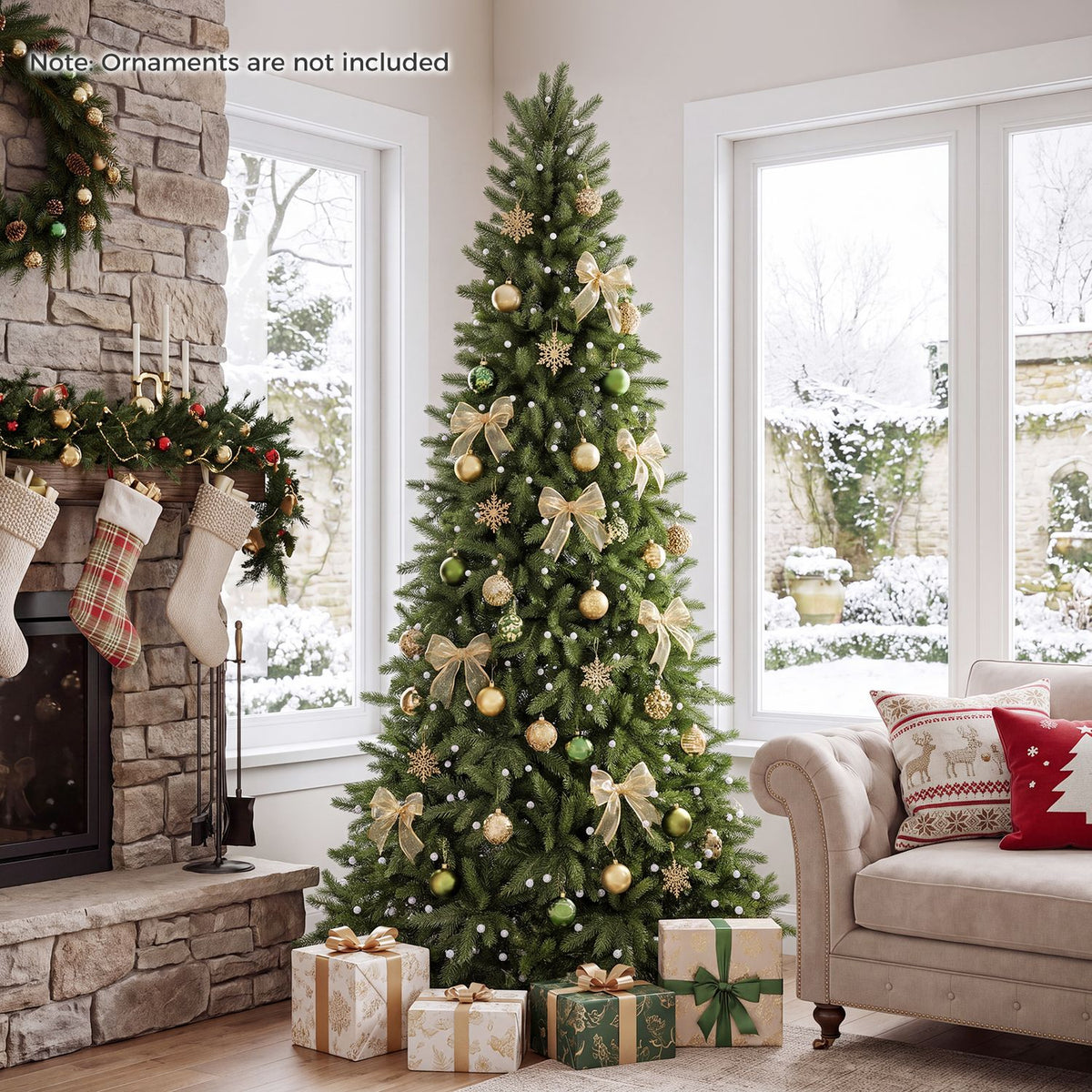 Green Christmas tree decorated with gold ornaments beside a fireplace and snowy windows