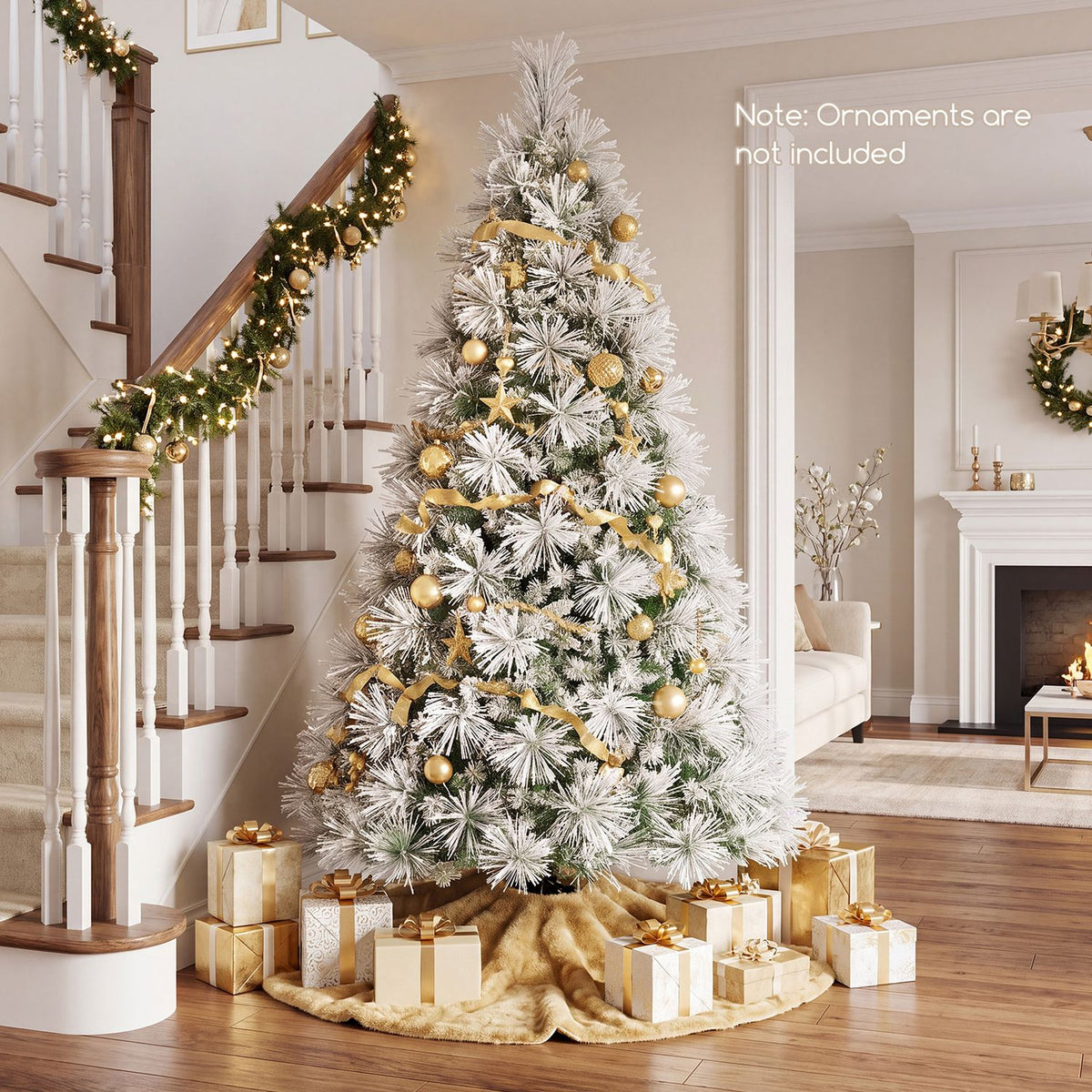 Snow-flocked Christmas tree decorated with gold ornaments and ribbon beside a staircase, with wrapped gifts below.