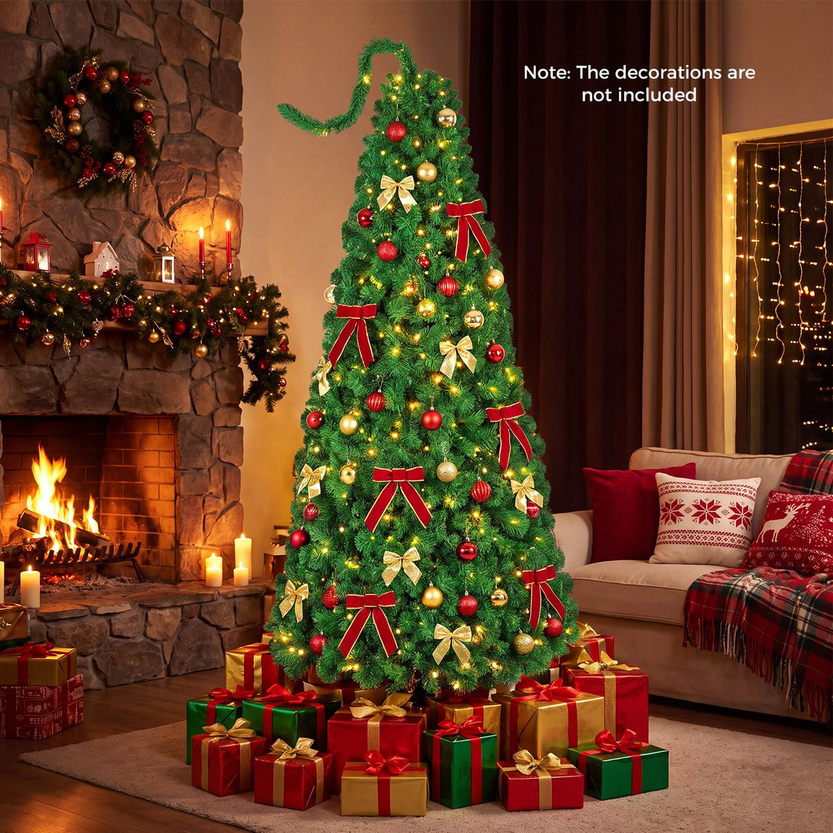 Green flocked Christmas tree glowing beside a stone fireplace, decorated with ornaments, bows and wrapped gifts.