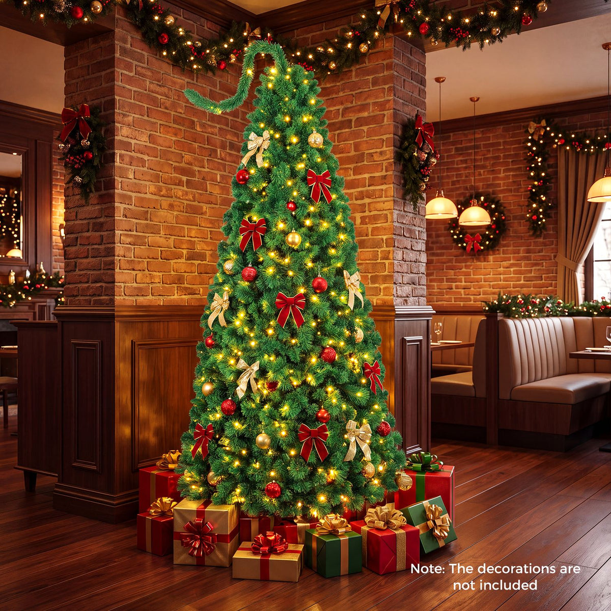 Lit green Christmas tree with red and gold ornaments in a brick-walled dining room, surrounded by presents.