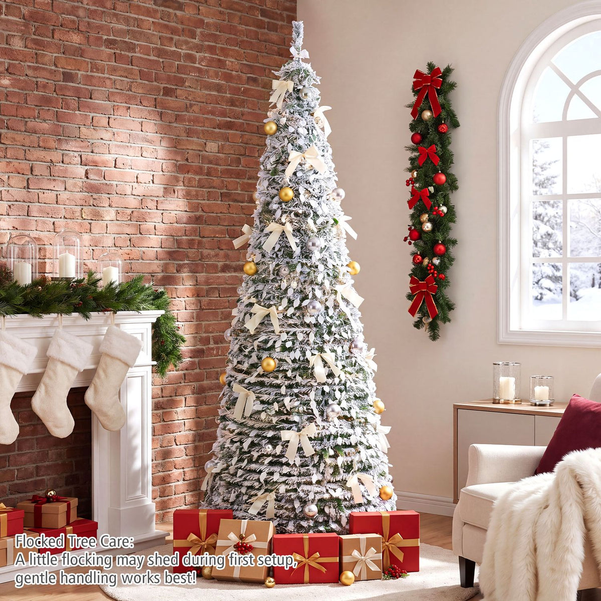 Flocked Christmas tree with warm lights, pale bows and gold ornaments beside a brick fireplace.