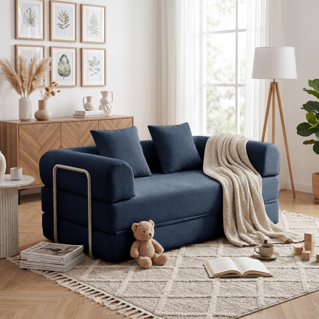 Navy blue corduroy convertible sofa shown as a compact two-seat couch with pillows and a draped throw
