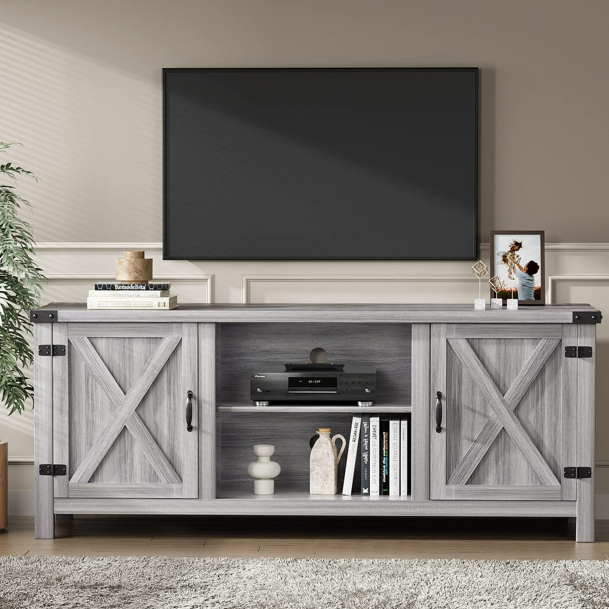 Front-facing gray wash TV stand with barn-door panels, open center shelving, and decorative items on top.
