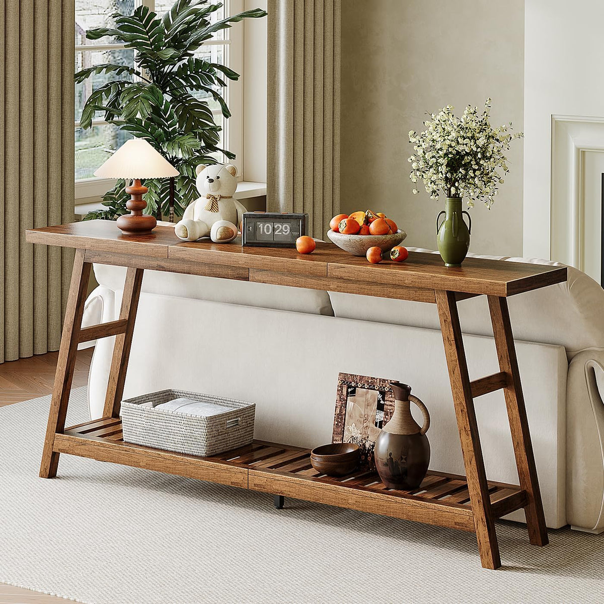 Walnut console table placed behind a sofa as a narrow sofa table with tabletop decor and open slatted storage below