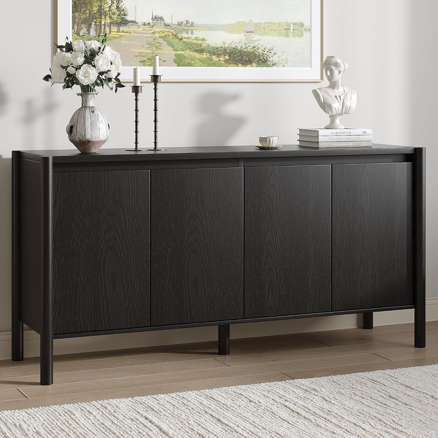 Black buffet showing subtle vertical wood grain and rounded outer frame beneath a framed landscape.