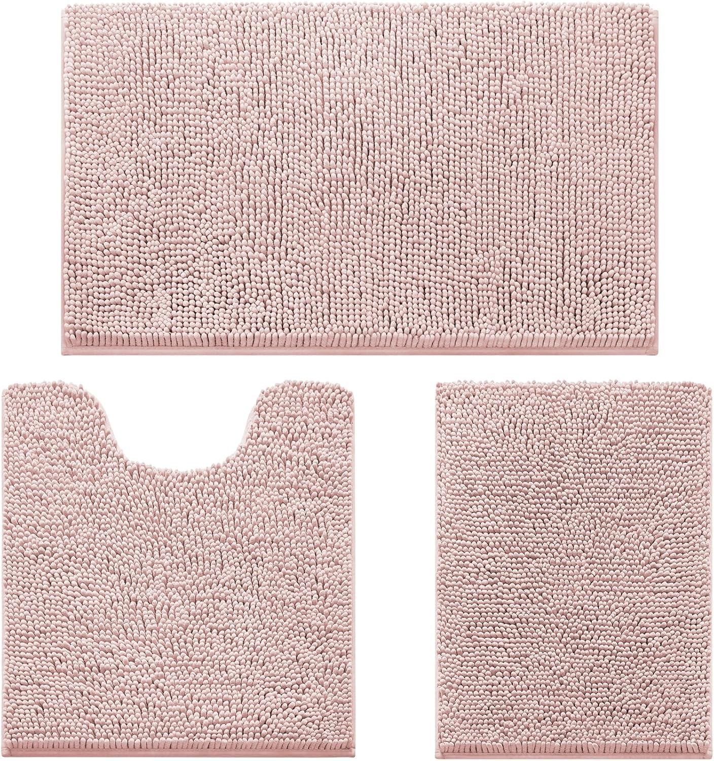 Three-piece blush pink chenille bath rug set shown flat: oversized mat, U-cut toilet rug, and matching smaller rug.