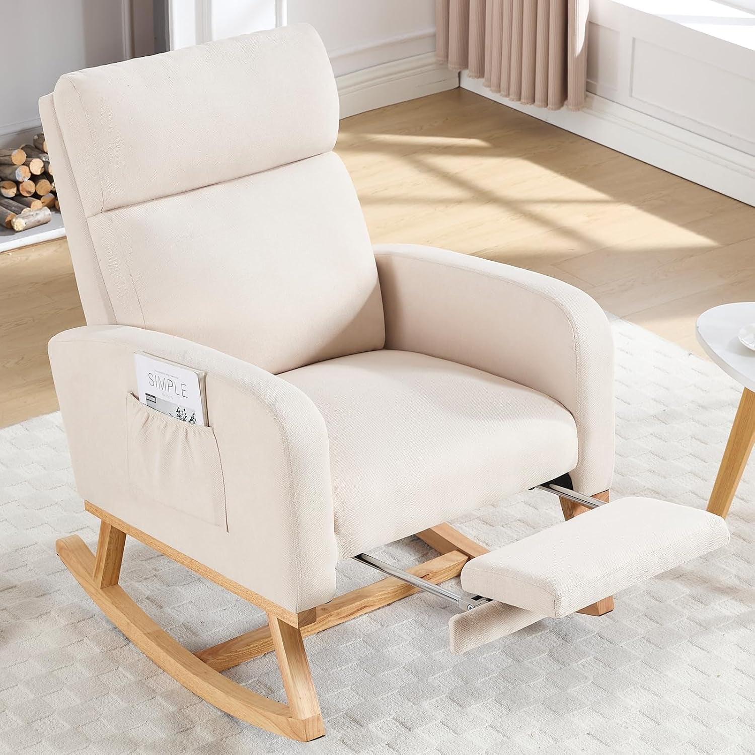 Beige upholstered rocking chair with wooden rocker legs and extended footrest in a bright living room.